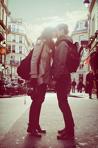 a man and woman kissing on a street