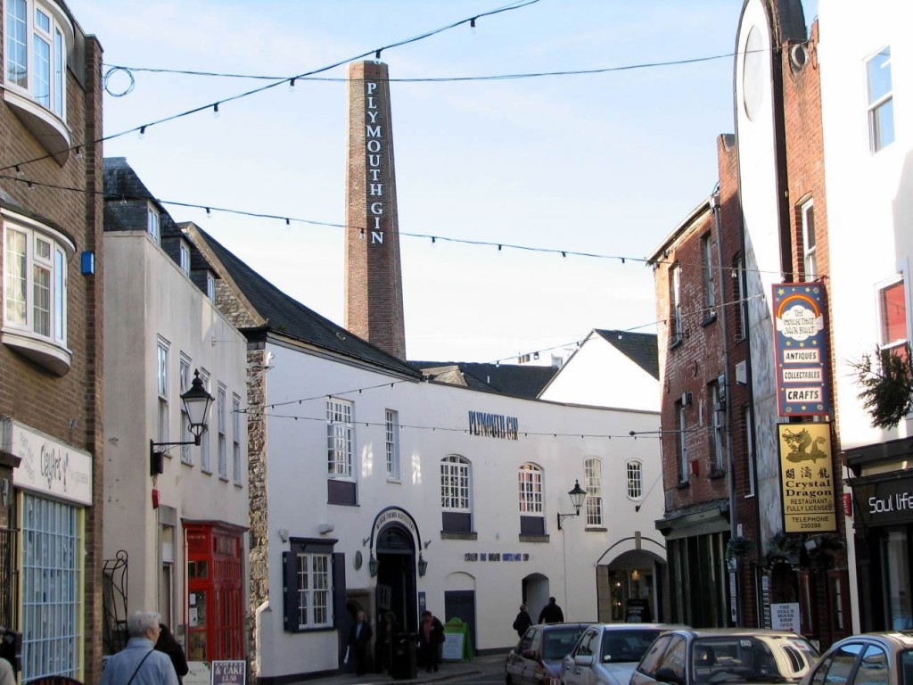 a street with buildings and cars with Plymouth Gin Distillery in the background