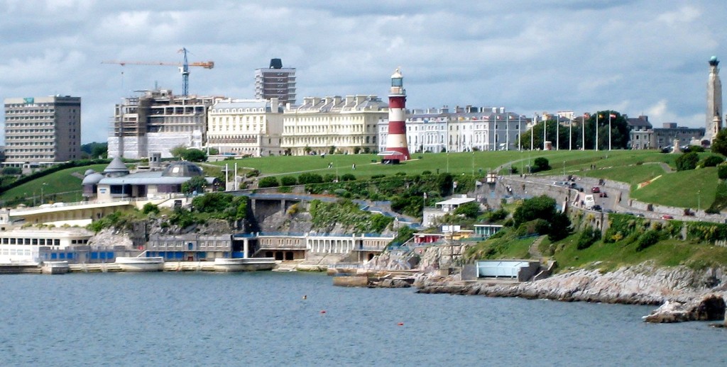 a lighthouse on a hill next to a body of water