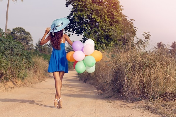 Woman walking away with balloons