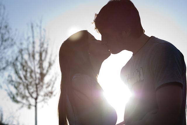 Couple kissing outside in shadow