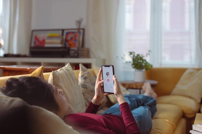 a person lying on a couch holding a phone