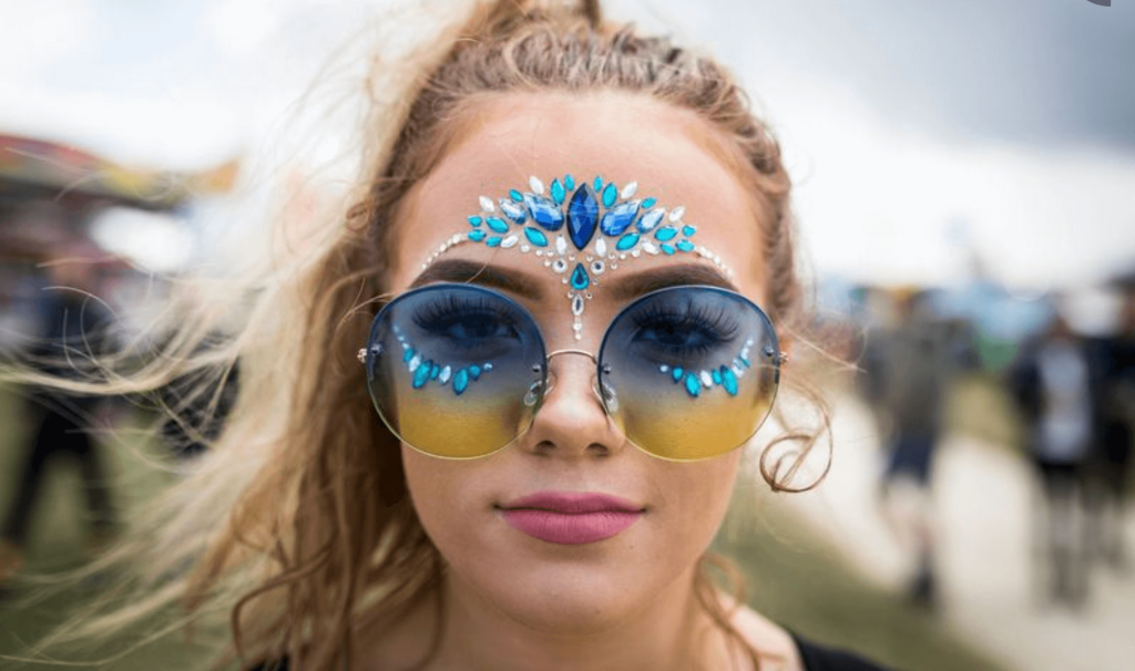 a woman with blue and white face paint and sunglasses